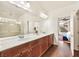 Well-lit bathroom boasts dual sinks and a glass-enclosed shower, complemented by modern finishes and fixtures at 5850 Rockway Glen Ave, Las Vegas, NV 89141
