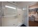 Elegant bathroom featuring a glass shower with a bench and an organized walk-in closet at 5850 Rockway Glen Ave, Las Vegas, NV 89141
