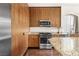 Modern kitchen features stainless steel appliances, stylish wood cabinets, and granite countertops at 5850 Rockway Glen Ave, Las Vegas, NV 89141