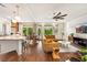 Open-concept kitchen and living room offers hardwood floors, granite counters, a modern ceiling fan and comfortable seating at 5850 Rockway Glen Ave, Las Vegas, NV 89141