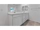 Bathroom vanity area with double sinks, white cabinets, and a white countertop at 5937 W Frias Ave, Las Vegas, NV 89141