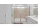 Bright bathroom featuring a glass shower with a built-in seat and a gray rug at 5937 W Frias Ave, Las Vegas, NV 89141