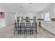 Open kitchen with an island, stainless steel appliances, tile backsplash, and sleek white cabinets at 5937 W Frias Ave, Las Vegas, NV 89141