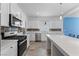 Kitchen features stainless steel appliances, white cabinets, a modern tile backsplash, and gas cooktop at 5937 W Frias Ave, Las Vegas, NV 89141