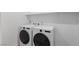 Laundry room featuring a white front-load washer and dryer, with white walls and shelving at 5937 W Frias Ave, Las Vegas, NV 89141