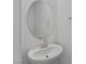 Stylish powder room featuring a modern oval mirror and sleek white sink at 5937 W Frias Ave, Las Vegas, NV 89141