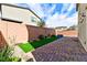 Landscaped backyard with brick pavers and artificial turf, offering a low-maintenance outdoor space at 6046 Castle Gardens Ave, Las Vegas, NV 89130