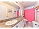 Well-lit bathroom features a granite countertop, a sink, and a bright pink shower curtain at 6046 Castle Gardens Ave, Las Vegas, NV 89130