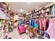 Spacious walk-in closet featuring custom shelving, hanging rods, and pink upholstered bench at 6046 Castle Gardens Ave, Las Vegas, NV 89130