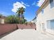 Expansive paved backyard featuring privacy walls, palm trees, and neutral-colored stucco exterior at 6269 Bold Regatta Ct, Las Vegas, NV 89139