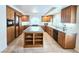 Large kitchen with an island, granite countertops, tiled floors, and wood cabinets at 6269 Bold Regatta Ct, Las Vegas, NV 89139