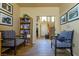 Inviting entryway featuring wood-look tile floors, staircase, and neutral walls, with reading nook and a view into the house at 6279 Dollar Bill Ct, Las Vegas, NV 89141