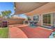 A cozy patio area featuring a sunshade, brick pavers, and chairs for relaxing and entertaining at 6433 Buck Jones Ave # 102, Las Vegas, NV 89122