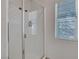 Bathroom featuring a glass-enclosed shower, tile walls and floors, and a window at 6433 Buck Jones Ave # 102, Las Vegas, NV 89122