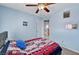 Bedroom featuring blue walls, neutral carpet, a ceiling fan and a window with blinds and a side curtain at 6433 Buck Jones Ave # 102, Las Vegas, NV 89122