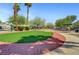 A well-manicured green space features lush greenery and a paved walking path at 6433 Buck Jones Ave # 102, Las Vegas, NV 89122