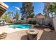 Secluded backyard boasting a pool, mature trees, and a fire pit sitting area at 6517 W Brooks Ave, Las Vegas, NV 89108