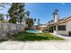 Sprawling backyard with lawn, swimming pool, patio dining, and block fence at 6517 W Brooks Ave, Las Vegas, NV 89108