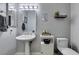 Tastefully decorated half-bathroom with pedestal sink and toilet at 6517 W Brooks Ave, Las Vegas, NV 89108