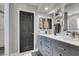 Renovated bathroom with gray vanity, dual sinks, and an adjoining tiled shower at 6517 W Brooks Ave, Las Vegas, NV 89108