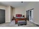 Bedroom boasting wood-look flooring, a gray ottoman, and ensuite bathroom access at 6517 W Brooks Ave, Las Vegas, NV 89108