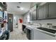 Functional laundry room with gray cabinets, counter space, and modern washer and dryer at 6517 W Brooks Ave, Las Vegas, NV 89108