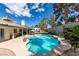 Inviting backyard with a sparkling pool, lush landscaping, and a spacious patio area perfect for outdoor entertaining at 6517 W Brooks Ave, Las Vegas, NV 89108