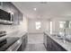Modern kitchen with granite countertops and stainless steel appliances, flowing into the living area at 7003 Crimson Shadow St, North Las Vegas, NV 89086