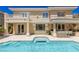 Backyard with pool and spa, covered outdoor kitchen, balcony, and a manicured lawn at 712 Proud Eagle Ln, Las Vegas, NV 89144