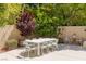 Spacious backyard patio featuring an outdoor dining set amidst lush landscaping at 712 Proud Eagle Ln, Las Vegas, NV 89144
