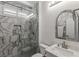 Elegant bathroom showcasing marble-like tiles, a glass-enclosed shower, and decorative mirror at 712 Proud Eagle Ln, Las Vegas, NV 89144