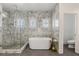 Luxurious bathroom featuring a modern soaking tub and a glass-enclosed shower with marble tile at 712 Proud Eagle Ln, Las Vegas, NV 89144