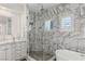 Beautiful bathroom with marble-tiled walls, glass-enclosed shower, and soaking tub at 712 Proud Eagle Ln, Las Vegas, NV 89144
