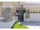 A beautifully landscaped entrance gate framed with stone accents leads to the home's front door and three-car garage at 712 Proud Eagle Ln, Las Vegas, NV 89144