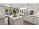 Bright kitchen featuring a large island, white cabinets, and direct access to the outdoor pool area at 712 Proud Eagle Ln, Las Vegas, NV 89144