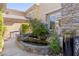 A tranquil pond featuring aquatic plants and koi fish creates a peaceful oasis near the front entrance at 712 Proud Eagle Ln, Las Vegas, NV 89144