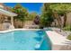 Backyard pool view featuring a beautiful waterfall, outdoor kitchen, and a spacious dining area at 712 Proud Eagle Ln, Las Vegas, NV 89144
