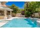 The pool area features a waterfall, outdoor dining, a fully equipped kitchen, and beautiful greenery at 712 Proud Eagle Ln, Las Vegas, NV 89144