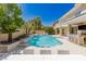 Beautiful backyard featuring a swimming pool, outdoor kitchen, and lounge areas at 712 Proud Eagle Ln, Las Vegas, NV 89144