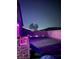 Night view of a backyard featuring a grass lawn, a small playground, a tree, and perimeter brick wall at 740 Omaggio Pl, Henderson, NV 89011
