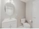 Bright bathroom featuring a vanity with a white sink, round mirror, toilet and white door at 776 Anacapri St, Las Vegas, NV 89138