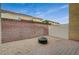 Backyard featuring a fire pit, gravel ground cover and a brick perimeter at 8261 Golden Flowers St, Las Vegas, NV 89139