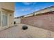Backyard featuring gravel ground cover, brick perimeter, and access to the house at 8261 Golden Flowers St, Las Vegas, NV 89139
