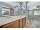 Bathroom featuring dual sinks with wood cabinets, tiled floors, and a separate toilet and shower area at 8261 Golden Flowers St, Las Vegas, NV 89139