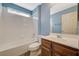 A well-lit bathroom features a shower-tub combo with white tile and a wood vanity at 8261 Golden Flowers St, Las Vegas, NV 89139