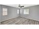 Bright bedroom with wood-look flooring, ceiling fan, and multiple windows providing ample natural light at 8261 Golden Flowers St, Las Vegas, NV 89139