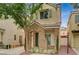 Inviting front exterior featuring a stone facade, desert landscaping, and shade tree at 8261 Golden Flowers St, Las Vegas, NV 89139