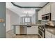 Open kitchen featuring white cabinets, stainless steel appliances, and access to the living area at 8261 Golden Flowers St, Las Vegas, NV 89139