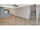 Open-concept living room featuring neutral paint, tiled floors, and staircase leading to upper level at 8261 Golden Flowers St, Las Vegas, NV 89139