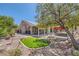 Lush backyard featuring a synthetic lawn, rock features, patio, and swing, perfect for outdoor enjoyment at 8325 Villa De Medici St, Las Vegas, NV 89131